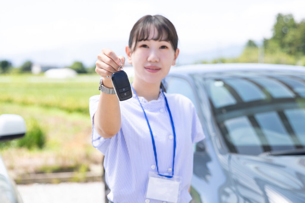 An image of a Japanese women handing over some car keys. 
