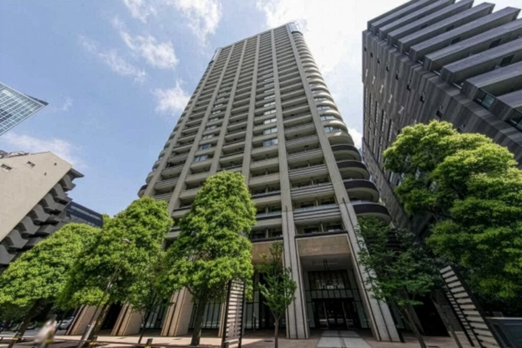 An image of the exterior of Park Court Toranomon Atago Tower, showing the modern curved design. Apartment for sale in Minato, Tokyo, Units for sale with Housing Japan