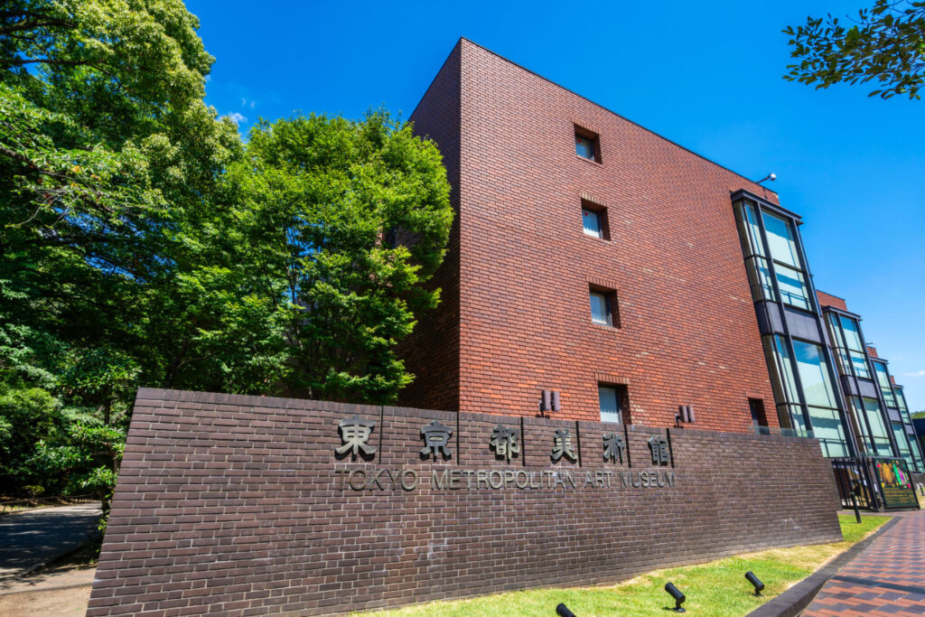 An image of the exterior of Tokyo Metropolitan Art Museum located in Ueno. red brick construction with its sign with the name in front.