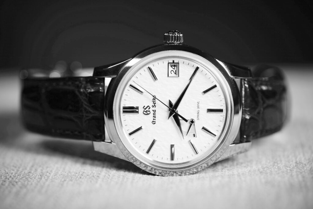 A black and white image of Grand Seiko SBGA407, also known as the Skyflake featuring a Spring Drive Movement. It has