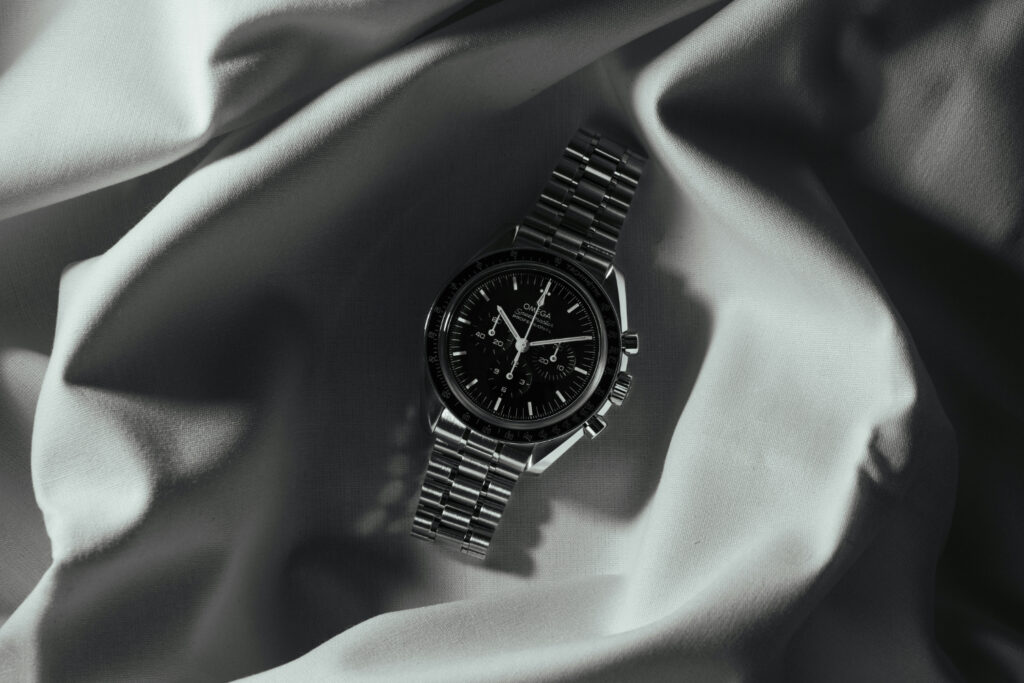 Luxury Watch Omega Speedmaster Professional sat inside some luxurious fabric.