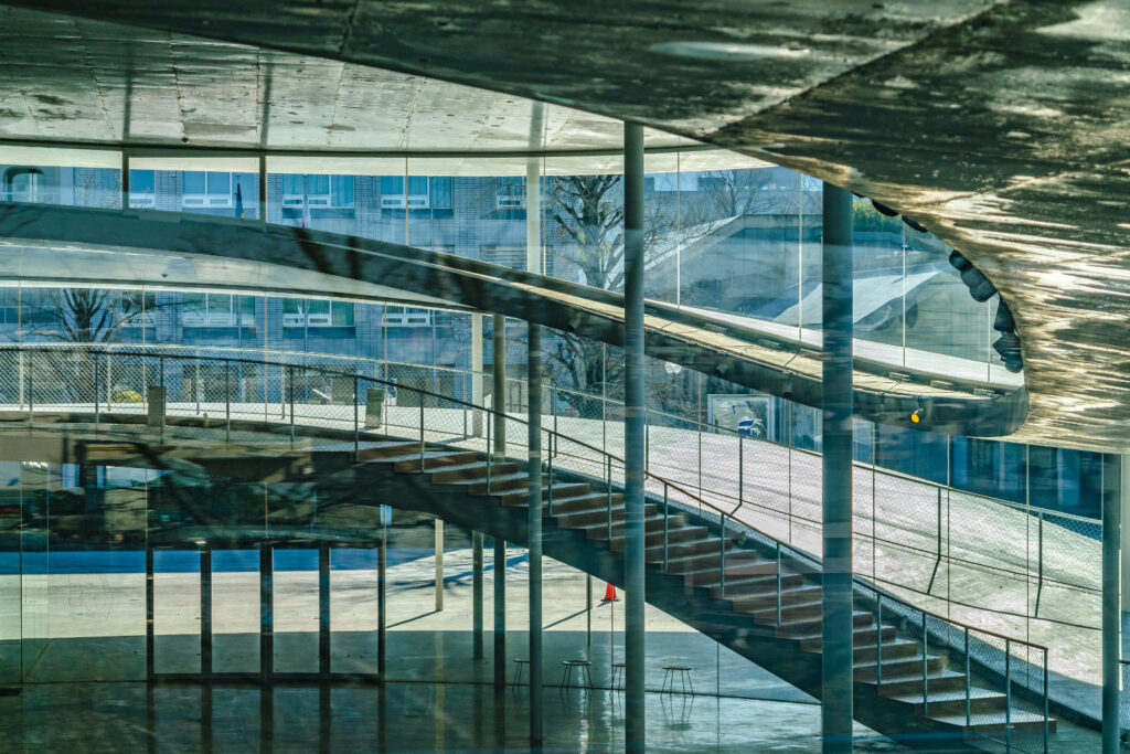 The Osaka University of Arts Exterior Building, Designed by SANAA. Glass, Chrome and natural curves, following Kazuyo Sejima design philohpy of Lightness, Openness, and Human Connection