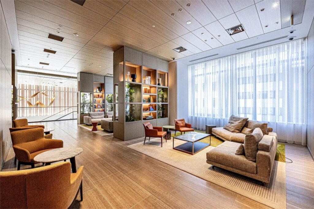 Communication lounge at World Tower Residence with timber panelling, display shelving and soft seating