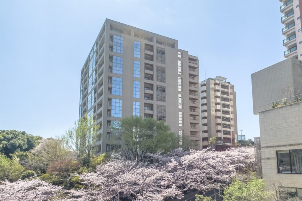 Exterior of The Westminster Roppongi, a 14-storey condominium in Minato Ward framed by cherry blossom trees in spring