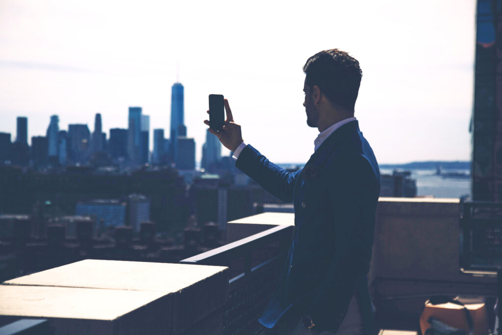 A businessman taking photos of a skyline view. 