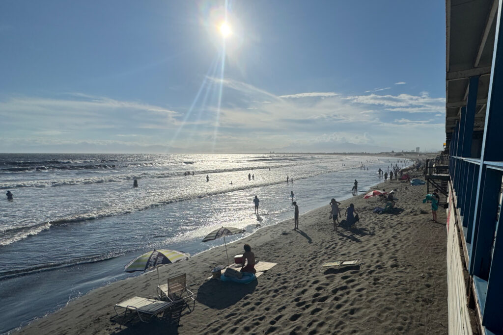 A view of the Enoshima beach in the summer with people sunbathing.