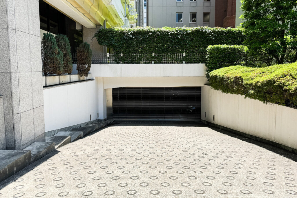 Ramp leading down to the shuttered underground car park of a condominium building in central Tokyo.